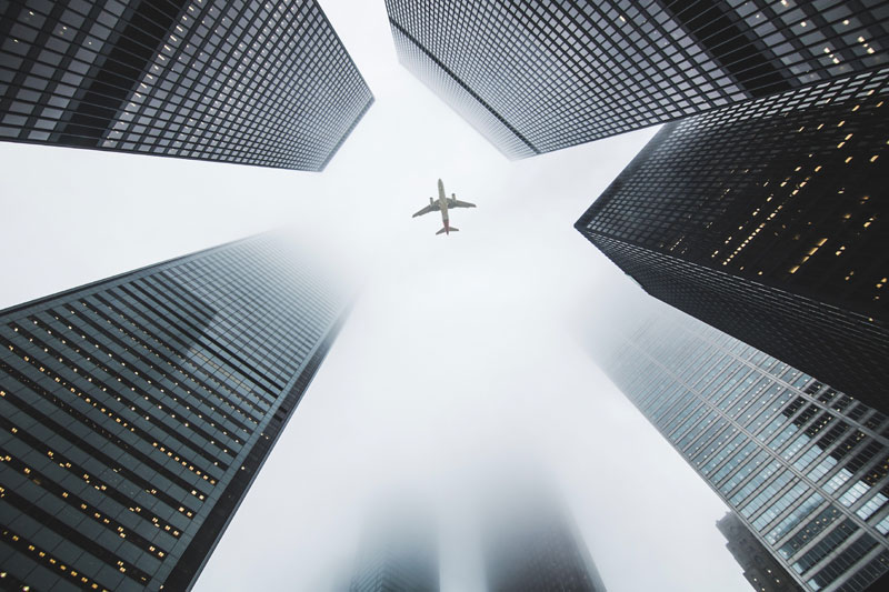 Plane flies over skyscrapers